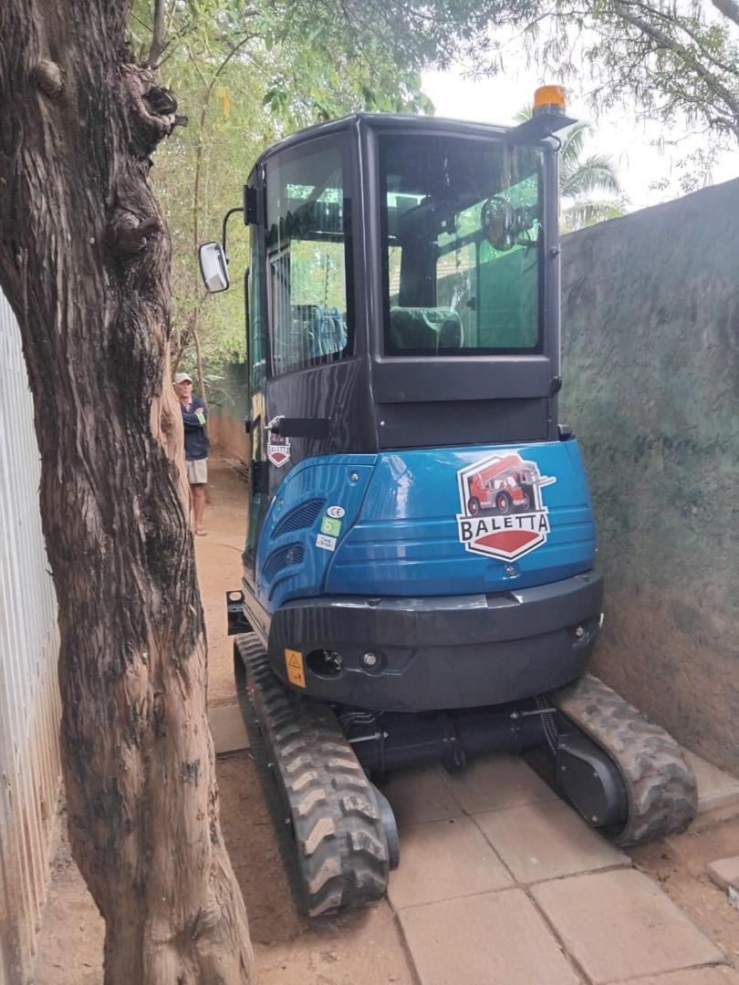 Rippa mini excavator on hire working a narrow paved side passage in Harare
